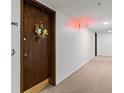 Hallway outside unit 402 with carpet, exit sign, and unit door with decorative wreath at 7430 Sunshine Skyway S Ln # 402, St Petersburg, FL 33711