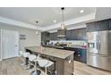 Modern kitchen with granite counters, stainless steel appliances, dark wood cabinets and island with seating at 12037 Conway St, Spring Hill, FL 34609