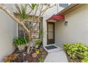 Welcoming front entrance with a cozy red awning and lush landscaping at 1205 Hounds Run, Safety Harbor, FL 34695