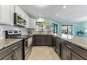 Modern kitchen featuring granite countertops, stainless steel appliances, and ample cabinet space at 1205 Hounds Run, Safety Harbor, FL 34695