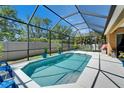 Backyard screened pool with bright blue lounge chairs and well maintained pool deck and fence at 12903 49Th E Ln, Parrish, FL 34219