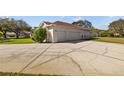 Three car garage with a wide concrete driveway and well-kept lawn at 13750 Dowling Ln, Odessa, FL 33556