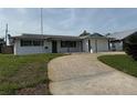 Well-maintained single-story home with a charming front yard and convenient driveway leading to an attached two-car garage at 14264 Page Ave, Largo, FL 33774