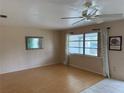 Inviting living room with wood flooring, a ceiling fan, and a large window offering ample natural light at 14264 Page Ave, Largo, FL 33774