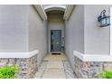 Inviting front entrance featuring stone accents and a welcoming 'WELCOME' sign at 16934 Oval Rum Dr, Wimauma, FL 33598