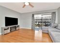Bright and airy living room with hardwood floors, ceiling fan, large sliding doors to the water at 200 Meres Blvd # 7, Tarpon Springs, FL 34689