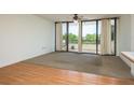 Bright living room with balcony access, ceiling fan, and a combination of carpet and laminate flooring at 30 Turner St # 502, Clearwater, FL 33756