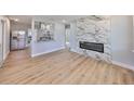Open floor plan with living room featuring a modern fireplace and wood-look floors at 3241 Williamsburg St, Sarasota, FL 34231