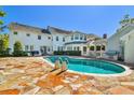 Backyard features a pool, stone patio, outdoor grill area and expansive lawn in this amazing home at 3313 W Mullen Ave, Tampa, FL 33609