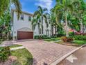 Elegant two-story home featuring a brick driveway, mature landscaping, and a Mediterranean-style facade at 511 Erie Ave, Tampa, FL 33606