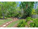 Lush backyard featuring a stone pathway, mature trees, and serene landscaping for outdoor enjoyment at 7816 Citrus Blossom Dr, Land O Lakes, FL 34637