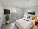 Bright bedroom features a comfortable bed with blue accents, a large window, and modern decor at 9481 Highland Oak Dr # 703, Tampa, FL 33647