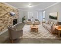 Inviting living room featuring a brick fireplace, neutral decor, stylish furnishings, and a soft patterned rug at 9481 Highland Oak Dr # 703, Tampa, FL 33647