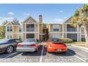 Charming condo exterior with red roof, screened porch, landscaping, and reserved parking at 9481 Highland Oak Drive # 602, Tampa, FL 33647