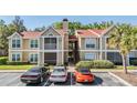 Inviting exterior of the condo showing its red roof, trees, and parking spaces at 9481 Highland Oak Drive # 602, Tampa, FL 33647