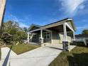 Angle view of the home showing the covered driveway and green exterior at 107 E Park St, Tarpon Springs, FL 34689