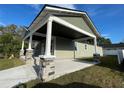 Angle view of the renovated home showing the driveway, porch, and well-maintained landscaping at 107 E Park St, Tarpon Springs, FL 34689