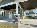 Charming home featuring stone pillar accents, a covered porch and a freshly painted exterior with well manicured lawn at 107 E Park St, Tarpon Springs, FL 34689