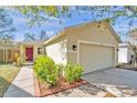 Charming single Gathering home showcasing a bright exterior paint, a two-car garage, and well-maintained landscaping at 11817 Mango Cross Ct, Seffner, FL 33584