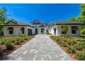 Beautifully landscaped modern home with a stone driveway and a symmetrical facade, reflecting luxury and elegance at 17720 Royal Eagle Ln, Lutz, FL 33549