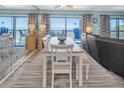 Dining room features an extended dining table with seating, and ocean view through sliding glass doors at 200 120Th W Ave # 3A, Treasure Island, FL 33706