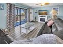 Living room has a fireplace, large sectional couch, and sliding doors to a balcony with an ocean view at 200 120Th W Ave # 3A, Treasure Island, FL 33706