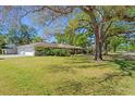 Spacious front yard featuring lush green grass and a home with an attached two car garage at 4302 W Woodmere Rd, Tampa, FL 33609