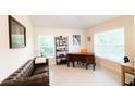 Cozy home office with a leather couch, a wooden desk, and natural light at 4444 Boyer Ter, North Port, FL 34288