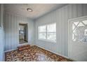 Cozy living room featuring unique tiled floors, wood walls and a large window at 503 W Lee St, Plant City, FL 33563