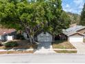 Charming single-Gathering home with mature trees, a paved driveway, and attached two-car garage at 7227 Otter Creek Dr, New Port Richey, FL 34655