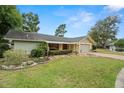 Charming single-story home with a well-maintained front yard, mature trees, and attached two-car garage at 112 Rosewood Ct, Palm Harbor, FL 34685