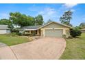 Charming single-story home with a well-maintained front yard, mature trees, and attached two-car garage at 112 Rosewood Ct, Palm Harbor, FL 34685