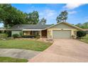 Charming single-story home with a well-maintained front yard, mature trees, and attached two-car garage at 112 Rosewood Ct, Palm Harbor, FL 34685