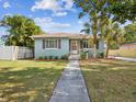 Charming single-story home with blue exterior, lush landscaping, and inviting walkway at 1225 26Th N St, St Petersburg, FL 33713