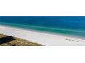Coastal aerial showcasing an expansive sandy beach alongside a tranquil ocean and lush greenery at 1390 Gulf Blvd # 104, Clearwater, FL 33767