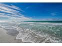 Beautiful ocean view with calming waves hitting the shoreline under a bright blue sky with scattered clouds at 1390 Gulf Blvd # 104, Clearwater, FL 33767