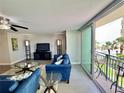Bright living room with stylish blue sofas and sliding glass doors to a balcony with ocean views at 1390 Gulf Blvd # 104, Clearwater, FL 33767