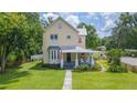 Inviting two-story home features a covered front porch, beautiful bay window, and well-maintained landscaping at 14006 5Th St, Dade City, FL 33525