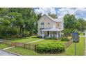 Corner lot showcasing a classic two-story home, picket fence, and manicured lawn under a bright sky at 14006 5Th St, Dade City, FL 33525