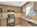 Classic kitchen with wood cabinets, stainless appliances, and a bright window view at 1421 Normandy Park Dr # 6, Clearwater, FL 33756