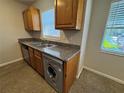 Efficient kitchen featuring granite countertops, wood cabinets, stainless appliances, and natural light at 212 S Church Ave # 105, Tampa, FL 33609