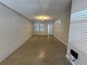 Bright living room features sleek flooring, fresh paint, and natural light from the window and glass front door at 212 S Church Ave # 105, Tampa, FL 33609