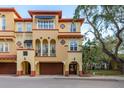 Beautiful Mediterranean-style townhome featuring arched entryways, a garage and red tile roofing at 264 Seagate Ct, Dunedin, FL 34698