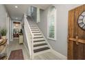 A view of the staircase featuring a white banister, black treads and shiplap accent walls at 264 Seagate Ct, Dunedin, FL 34698