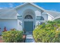 Inviting front entrance with double doors, arched window, and lush landscaping at 4228 Presidential Avenue E Cir, Bradenton, FL 34203