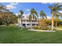 Beautifully landscaped yard with lush green grass and tropical landscaping at 450 Bayshore Dr, Terra Ceia, FL 34250