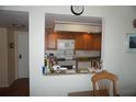 Cozy kitchen with white appliances, oak cabinets, and a pass-through to the adjacent living area at 4900 Brittany S Dr # 1706, St Petersburg, FL 33715