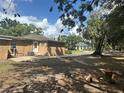 Spacious backyard with a glimpse of a neighboring house under a bright sky at 703 E Hamilton Ave, Tampa, FL 33604