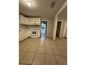 Bright kitchen featuring white cabinets and an electric range oven at 703 E Hamilton Ave, Tampa, FL 33604