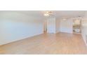 Spacious living room showcases light wood floors, ceiling fans, and an open layout flowing into the kitchen at 7081 Lafayette N, Pinellas Park, FL 33781